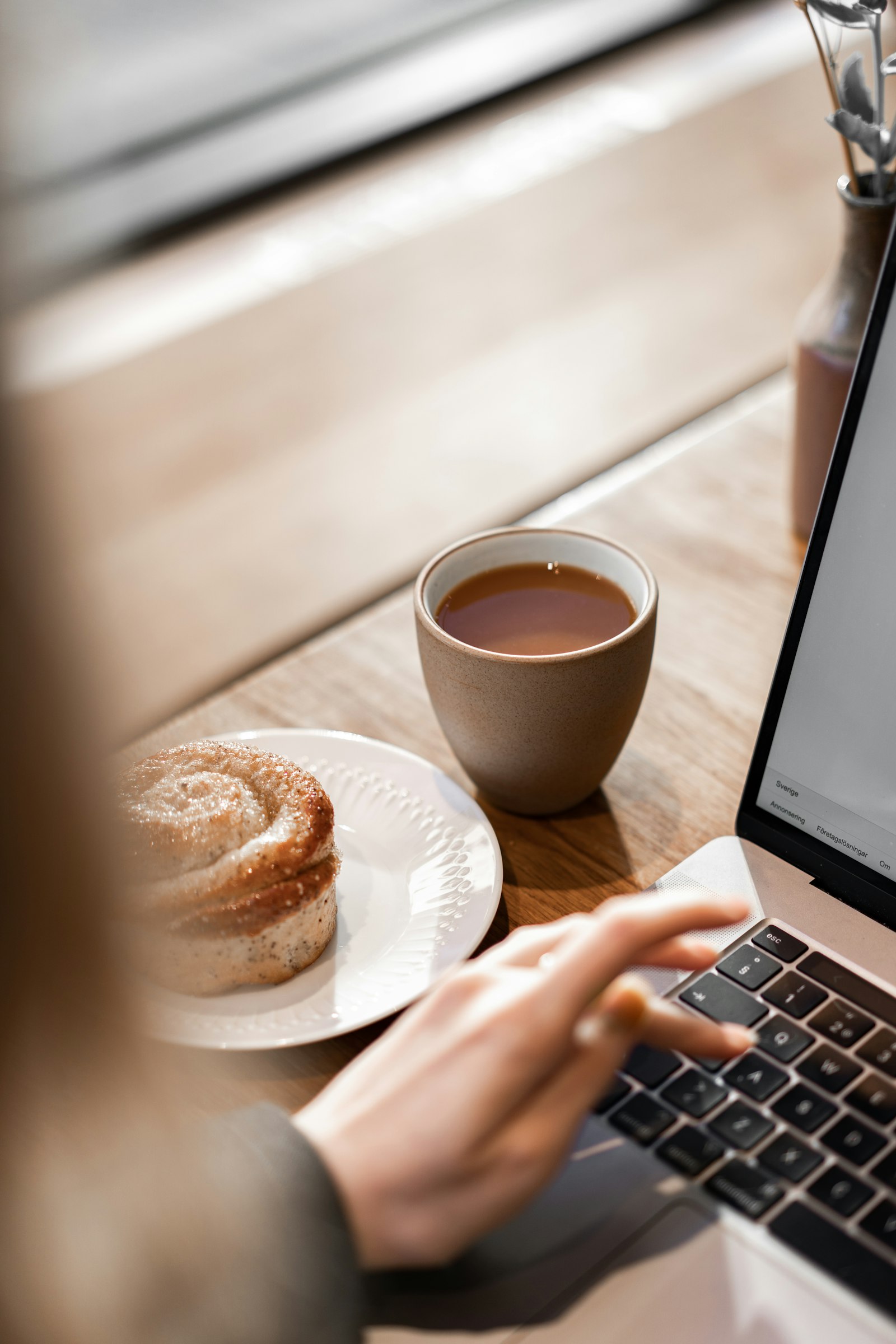 Varm arbeidsplass — kaffe, bolle, laptop